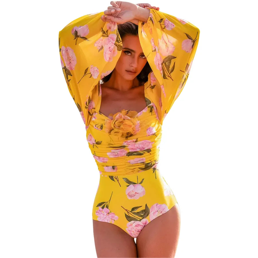 Maiô floral amarelo com mangas bufantes de tule e aplicação de flor em 3D no busto, moda praia feminina elegante.