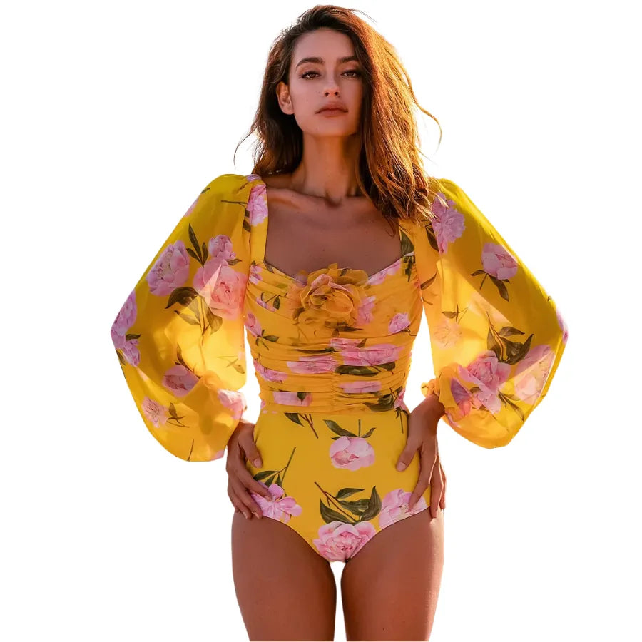Maiô floral amarelo com mangas bufantes de tule e aplicação de flor em 3D no busto, moda praia feminina elegante.