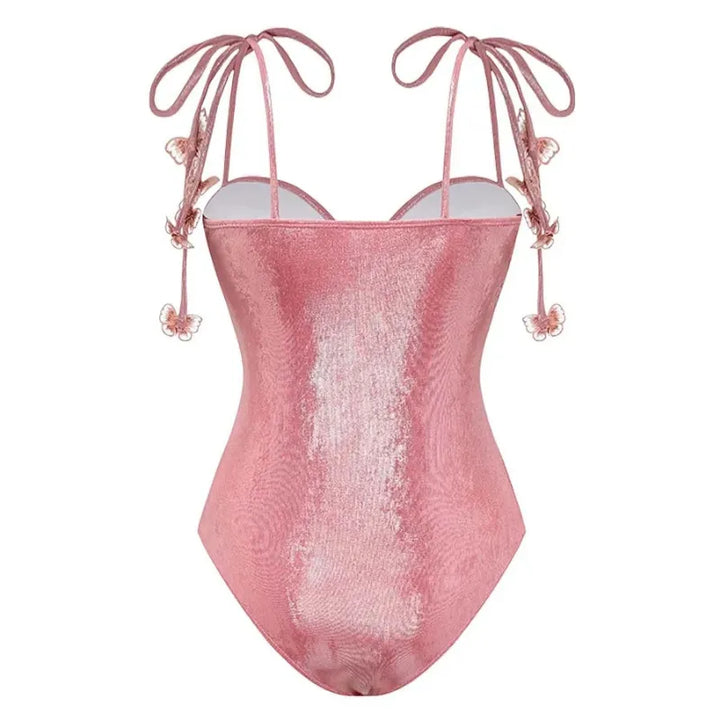 Maiô rosa cintilante com alças de amarrar nos ombros e apliques de borboletas em relevo por toda a peça, modelagem com bojo estruturado e brilho elegante.