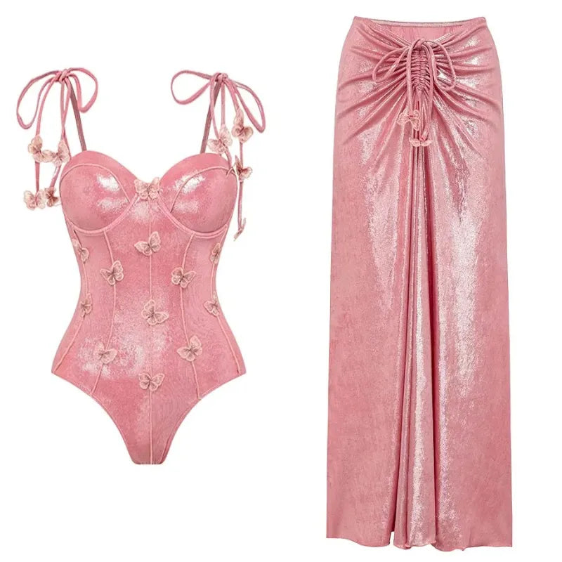 Saída de Praia e Maiô rosa cintilante com alças de amarrar nos ombros e apliques de borboletas em relevo por toda a peça, modelagem com bojo estruturado e brilho elegante.