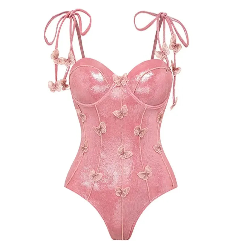 Maiô rosa cintilante com alças de amarrar nos ombros e apliques de borboletas em relevo por toda a peça, modelagem com bojo estruturado e brilho elegante.