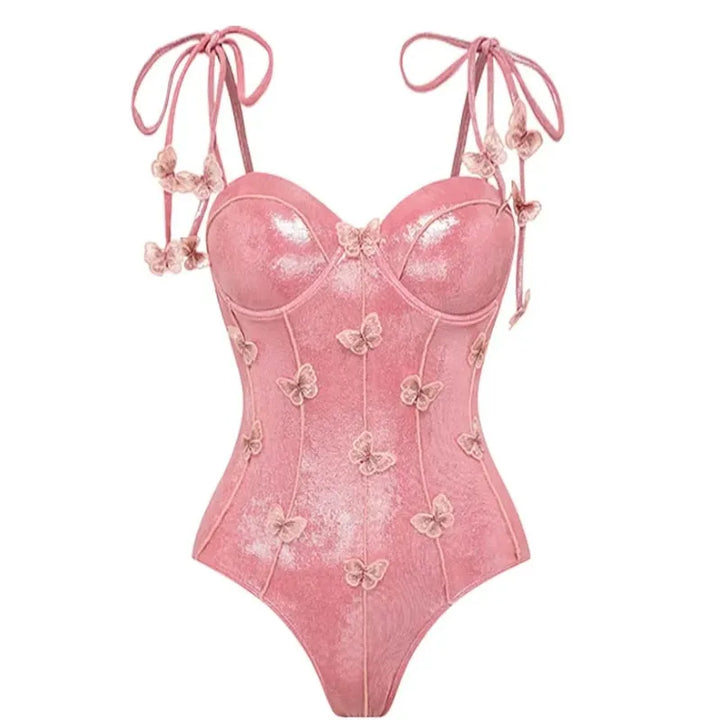 Maiô rosa cintilante com alças de amarrar nos ombros e apliques de borboletas em relevo por toda a peça, modelagem com bojo estruturado e brilho elegante.